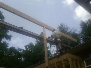 Carpenter setting a ridge beam over a new addition frame — Ice Dam Removal by Roofing Brothers in Richlandtown