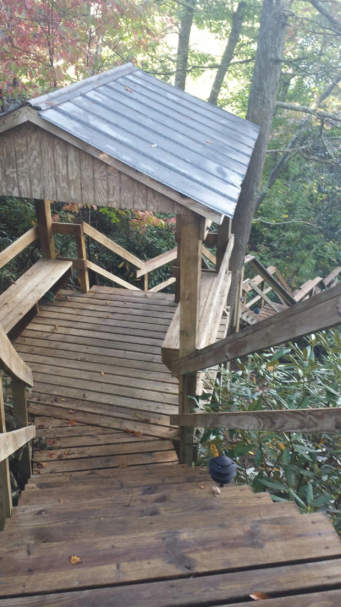 Metal roofed shelter over wooden steps on a wooded walkway — Skylight Repair & Installation work by our crew in Richlandtown
